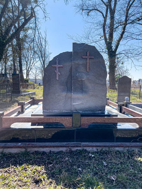 Dwa groby z krzyżami na cmentarzu w słoneczny dzień. - Zdjęcie, obraz