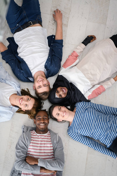 a padlón heverő és az összetartást szimbolizáló emberek sokszínű csoportjának csúcsképe. - Fotó, kép