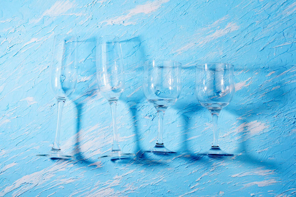 Leere Weingläser, der Behälter für das alkoholische Getränk. blauer Hintergrund. - Foto, Bild