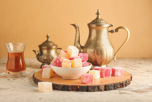 Bowl with Turkish delight and teapot on table - Photo, Image