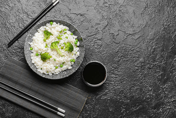 Plate with tasty rice and broccoli on dark background - Φωτογραφία, εικόνα
