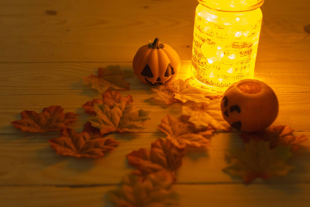 Halloweenpompoenen met beschilderde gezichten op een houten tafel. Halloween achtergrond. Ruimte voor tekst. kopieer ruimte. Halloween concept - Foto, afbeelding