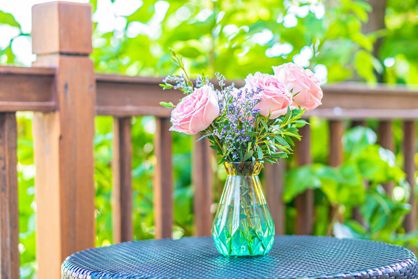 Bellissimo fiore in vaso sulla decorazione della tavola con vista sul giardino - Foto, immagini