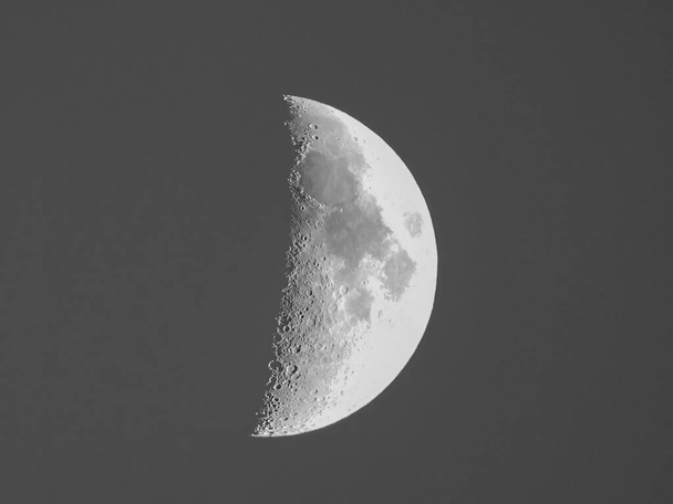 Primer cuarto de luna visto con un telescopio astronómico, cielo en blanco y negro - Foto, Imagen
