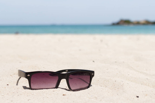 Солнечные очки запятнаны песком. Летние каникулы - Фото, изображение