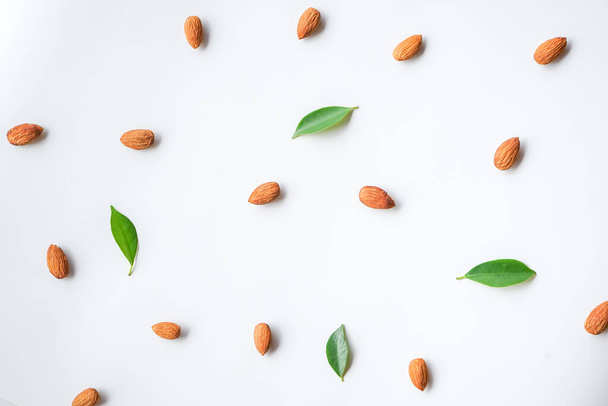 vista superior de amendoins e folhas verdes sobre fundo branco - Foto, Imagem