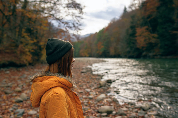 woman hiker admires nature in the mountains autumn river - Valokuva, kuva