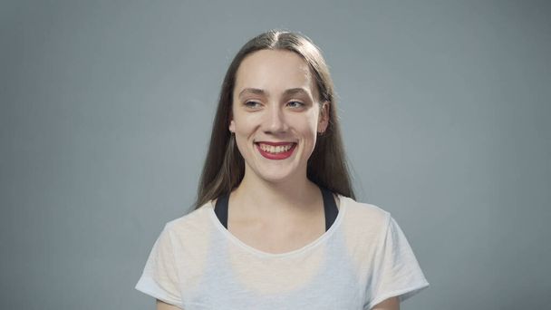 Фото молодої усміхненої жінки на сірому
 - Фото, зображення