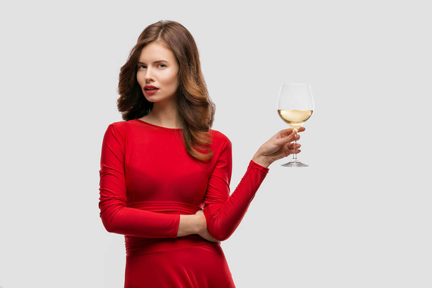 Beautiful woman holding glass of wine onwhite background - Фото, изображение