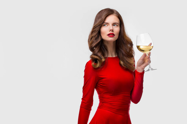 Hermosa mujer sosteniendo copa de vino sobre fondo blanco - Foto, Imagen