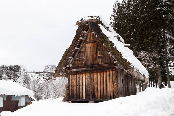 Традиционный дом в стиле гассо в деревне Ширава-го зимой в японском городе Гималаи. Село Сиракава-го является одним из объектов всемирного наследия ЮНЕСКО. - Фото, изображение