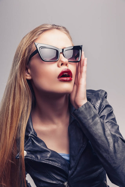 Modeporträt eines schönen Mädchens mit Sonnenbrille. Nahaufnahme von niedlichen Frau auf weißem Hintergrund, isoliert. - Foto, Bild