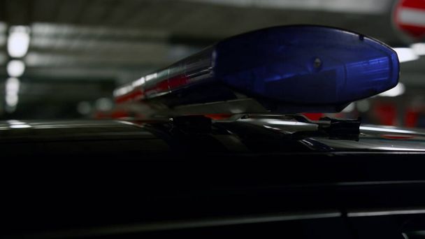 Κόκκινα και μπλε φώτα λάμπουν στο περιπολικό. Φωτισμός σειρήνας στην οροφή του οχήματος - Φωτογραφία, εικόνα