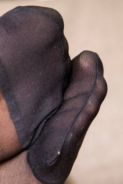 Um retrato de perto dos dedos dos pés reforçados de nylon preto meia-calça ou meias de pés de uma mulher. Você pode ver todos os detalhes finos do tecido e as costuras. - Foto, Imagem