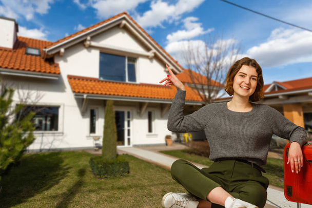 Happy woman on the background of a new house. Portrait of first time buyer, house owner, apartment renter, flat tenant or landlady. Moving day and buying own property concept - Fotografie, Obrázek