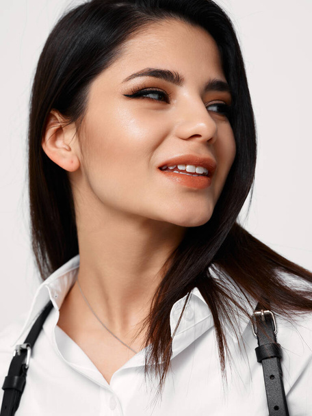 happy brunette in white shirt with black suspenders fashion style cosmetics - Фото, зображення