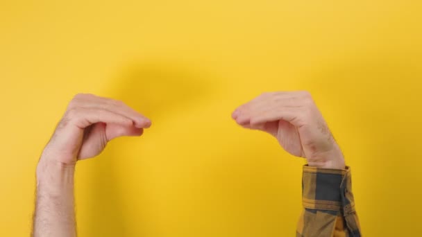 Zwei Männerhände unterhalten sich untereinander amüsant und verkörpern die Gesprächspartner. Gelber Hintergrund. Kommunikationskonzept. - Filmmaterial, Video