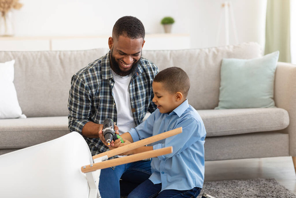 African American Son And Father Fixing Table At Home - Photo, Image