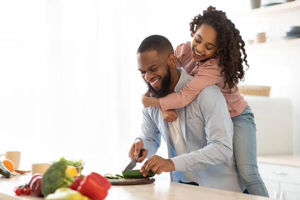 Afrikaanse Amerikaanse vader en dochter koken salade - Foto, afbeelding