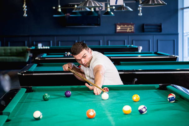 Adult men with disabilities in a wheelchair play billiards in the club - Photo, Image