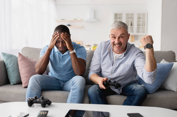 Emotions of people, victory and loss in online game at home with friend - Photo, Image