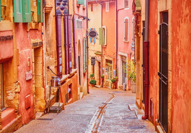 Een smalle straat in het prachtige Franse dorp Roussillon, waar de gebouwen zijn gemaakt van lokaal gedolven oker en er wordt gezegd dat er 17 verschillende tinten van kleur. - Foto, afbeelding