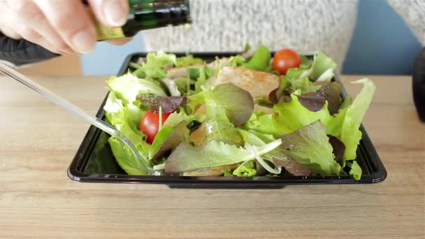 Frau gießt Olivenöl in den Salat. vegetarisch-vegane Bio-Kost. gesunde Ernährung. Fast Food zum Mitnehmen. Essen im Restaurant. - Filmmaterial, Video