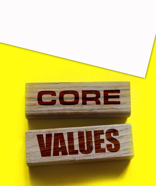 Sarı arka planda tahta bloklardaki temel değerler. İş ahlakı kavramı. - Fotoğraf, Görsel