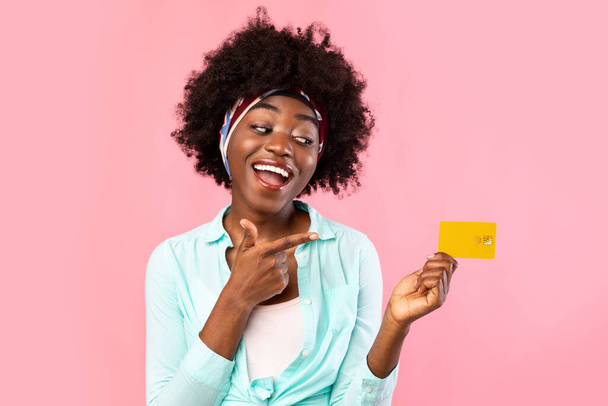 Cheerful Black Woman Pointing Finger At Credit Card In Studio - Фото, изображение