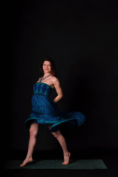 A beautiful Caucasian woman posing in an elegant blue dress on a black background - Fotografie, Obrázek