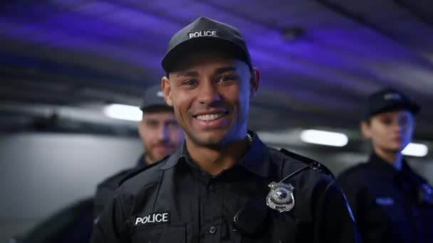 Politieagent lacht naar de camera. Positieve agent in uniform poseren op camera - Video