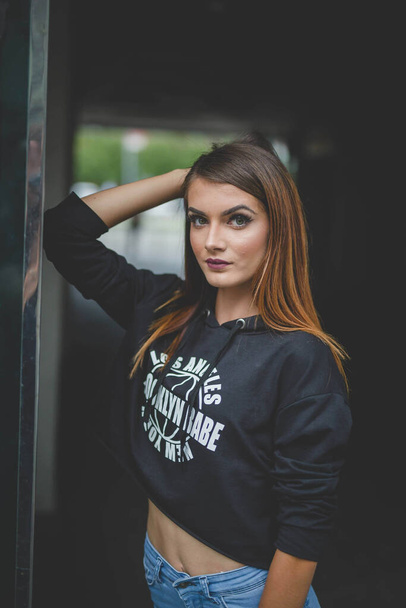 A vertical shot of a young female model in casual clothing posing in a tunnel - Fotografie, Obrázek