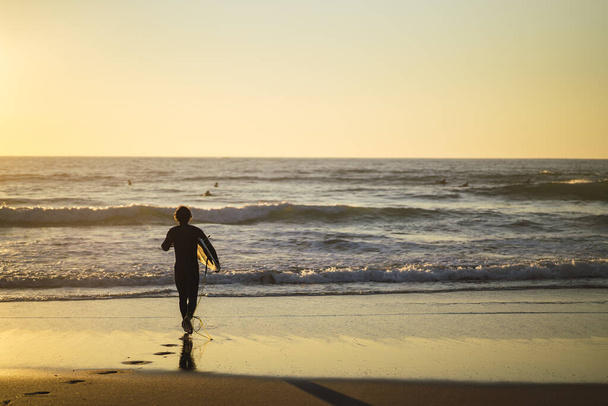 A beautiful shot of a person running on the beach at sunset - Fotó, kép