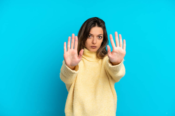 Mladá běloška žena izolované na modrém pozadí dělat stop gesto a zklamání - Fotografie, Obrázek