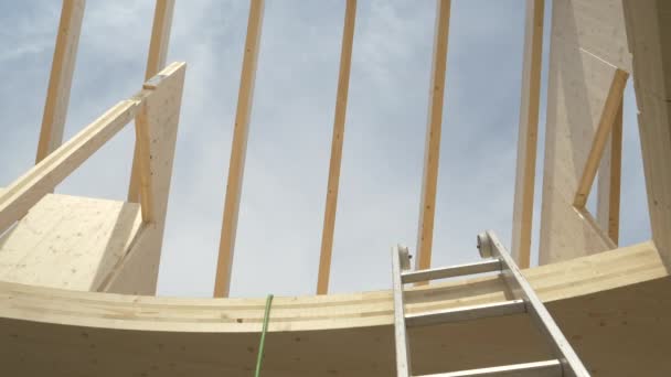 BOTTOM UP: Heldere luchten overspannen dakbalken van een CLT-huis in aanbouw. - Video
