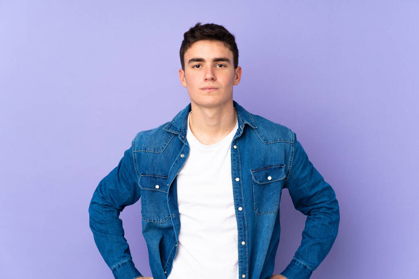 Teenager caucasian  handsome man isolated on purple background angry - Φωτογραφία, εικόνα