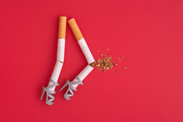 Sigaretten als benen met knieblessure, slechte effecten van roken op gezondheid, botten en gewrichten creatief concept. - Foto, afbeelding