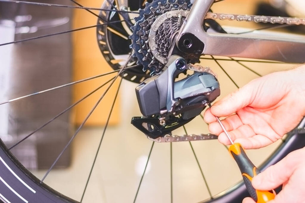 Крупный план процесса регулировки части велосипеда с помощью инструмента - Фото, изображение