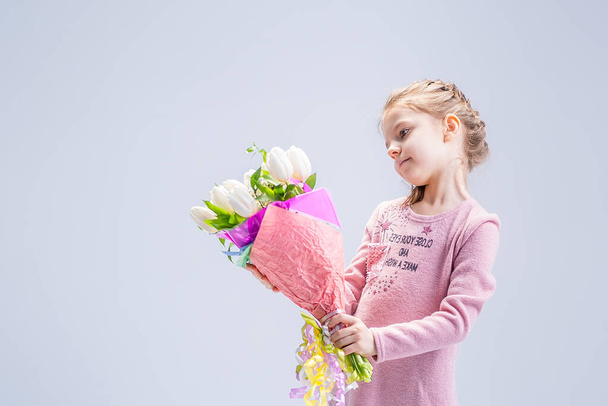 beautiful little girl with a bouquet of white tulips - Foto, Imagen