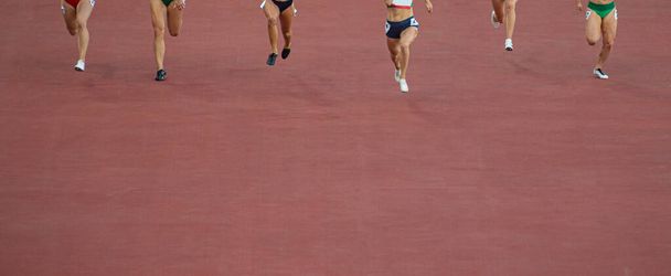 Juokseva nainen juoksee juoksijoita 100 metrin päässä. Ammattiurheilun käsite - Valokuva, kuva