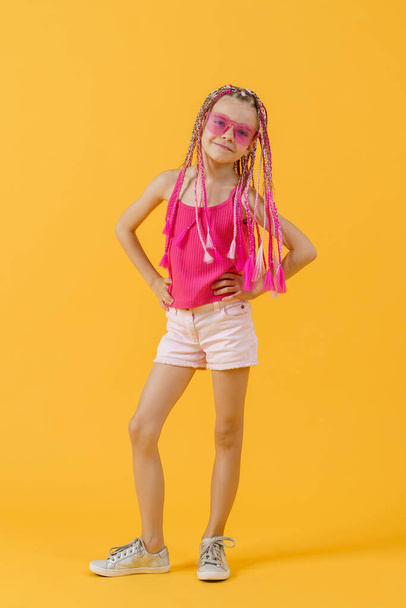 Stylish girl with pink dreadlocks and posing on a yellow backgro - Foto, Imagem