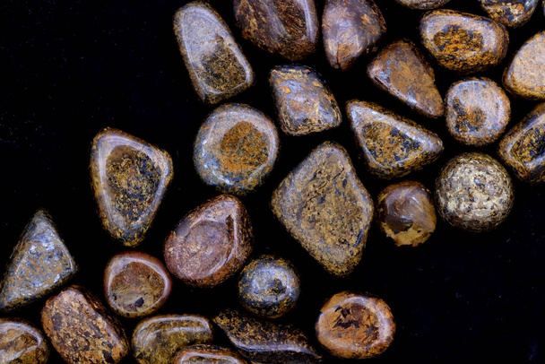 Bronzite heap up jewel stones texture on black background - Foto, afbeelding