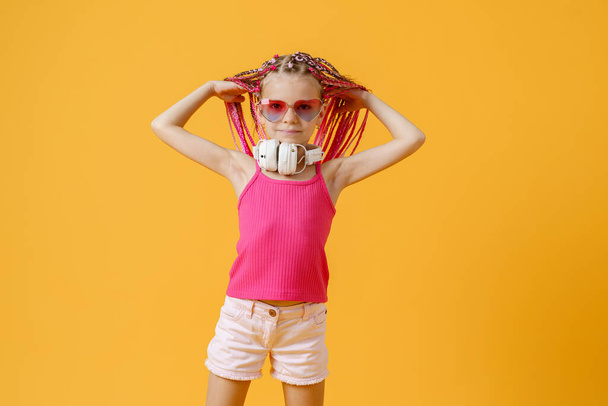 Trendy DJ girl in bright clothes, headphones and bright dreadloc - Foto, afbeelding