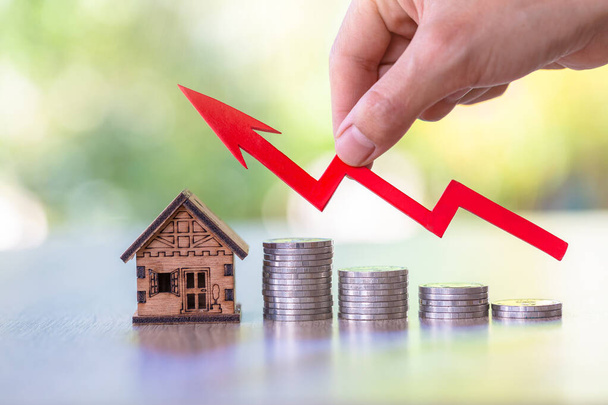 Büyüyen ev minyatürünün üzerinde el ele tutuşma grafiği. Emlak yatırımı ve ev kredisi finansal konsepti, yatırım mülkü, gayrimenkul, tasarruf. - Fotoğraf, Görsel
