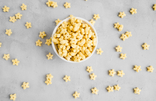 Honey stars breakfast cereal in white bowl. Healthy whole grain taste. Top view. Food for children. - Fotografie, Obrázek