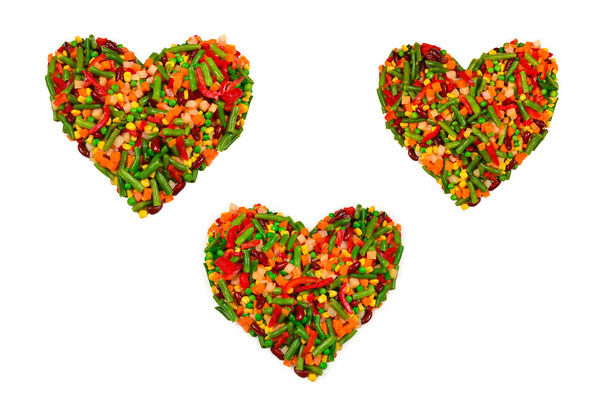 Coeur fait de légumes. Maïs, carotte, poivron, haricots verts. Isolé sur blanc.  - Photo, image