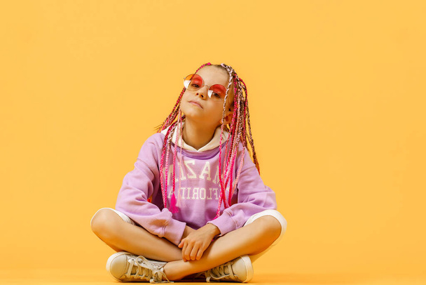 Stylish girl in rounded glasses with pink dreadlocks sitting, lo - Fotoğraf, Görsel