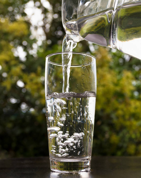 A closeup shot of water pouring into a glass - Photo, Image