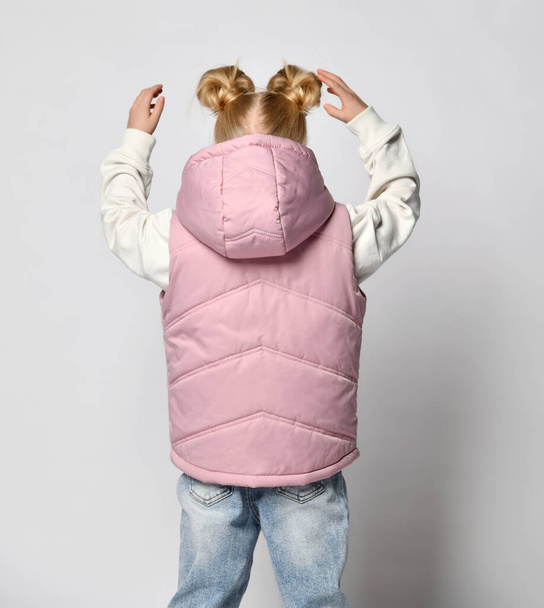 Girl in casual pink outwear sleeveless vest with hood back view studio shot - 写真・画像