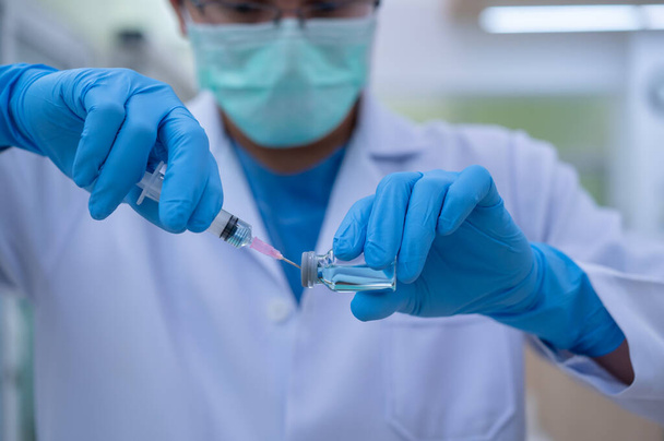 De arts bereidt een vaccin voor om in steriele boosters te worden geplaatst voor gebruik bij patiënten die geïnfecteerd zijn met het pandemische virus.. - Foto, afbeelding
